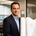 Toronto real estate developer standing in a modern project office beside rolled site plans