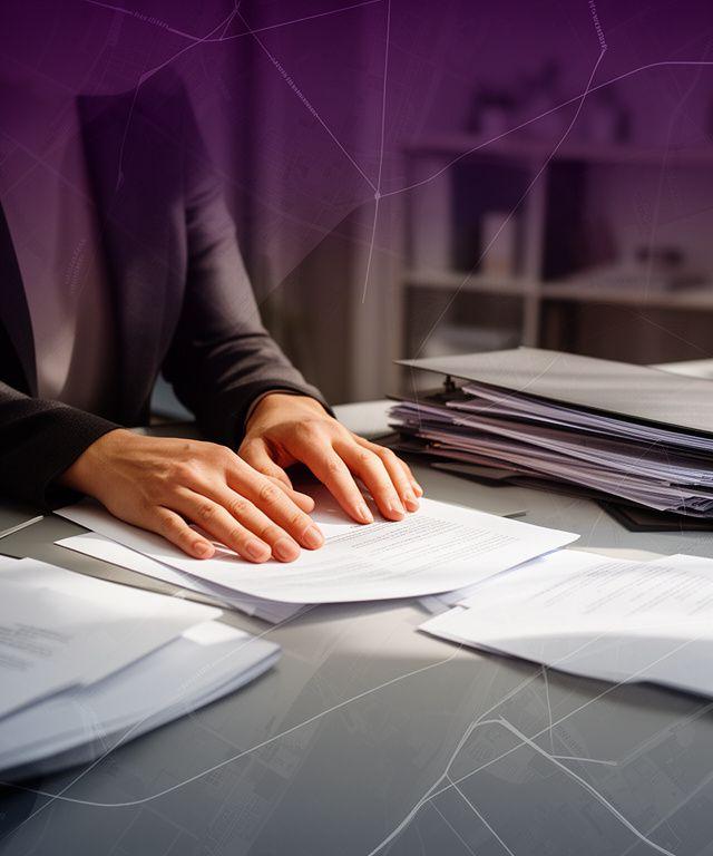 Legal consultant reviewing property documents beside a drafting table with map overlays in a Toronto office